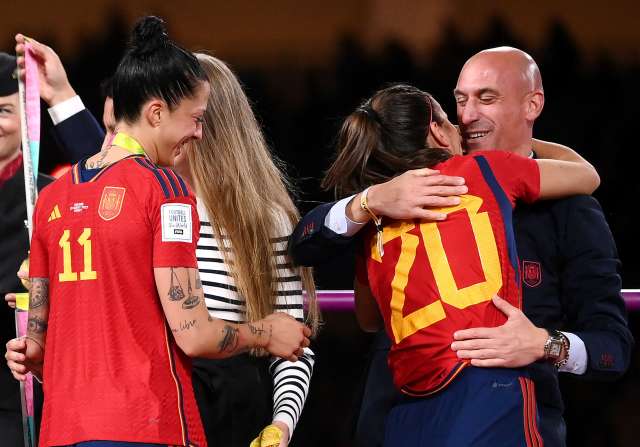 Image de Football. Le président de la Fédération espagnole de football, Luis Rubiales, est au cœur d'une controverse après avoir embrassé de force la joueuse Jenni Hermoso sur la bouche lors des célébrations de la victoire de l'équipe espagnole en Coupe du monde féminine. La joueuse, bien que l'ayant pris à la légère, a déclaré qu'elle n'avait pas apprécié le geste. Dans sa défense, Rubiales a qualifié le baiser d'un acte entre "deux amis" et a répondu aux critiques en disant : "N'écoutons pas les idiots et les gens stupides." Malgré les déclarations de Rubiales et d'Hermoso affirmant qu'il s'agissait d'un geste d'amitié et de gratitude, la polémique persiste. Selon vous, où se situe la limite entre l'expression d'une camaraderie sincère et un comportement inapproprié, en particulier dans un contexte professionnel comme le sport ?