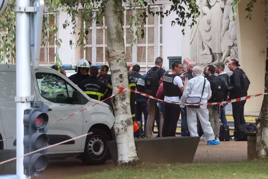 Image de Faits Divers. Un drame s'est produit ce matin à Arras. Un homme armé d'un couteau a attaqué un lycée, tuant au moins un enseignant et blessant gravement deux autres personnes. L'assaillant, d'origine tchétchène et fiché pour radicalisation, a été interpellé par la police, tout comme son frère. La situation a suscité une vive émotion et une mobilisation des forces de l'ordre. Le Parquet national antiterroriste a ouvert une enquête sur cette attaque, qui rappelle douloureusement l'assassinat de Samuel Paty il y a trois ans. Le président Macron est arrivé au lycée d’Arras. Comment renforcer la sécurité dans les écoles et prévenir de telles attaques à l'avenir ?