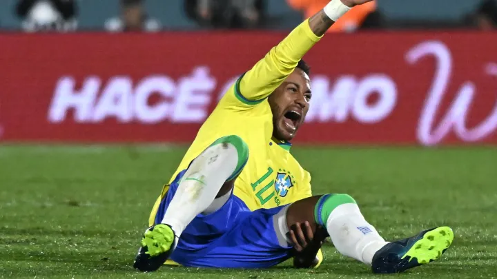 Image de Football. La nouvelle de la blessure de Neymar, qui s'est produit lors du match entre le Brésil et l'Uruguay, a secoué le monde du football. Le talentueux attaquant brésilien souffre d'une rupture des ligaments croisés du genou gauche, une blessure qui le privera de la compétition pendant une période indéterminée. Cette blessure est un coup dur pour Neymar, son club Al-Hilal, l'équipe nationale brésilienne, ainsi que pour les fans de football du monde entier. La blessure s'est produite lors du match crucial entre le Brésil et l'Uruguay, un match comptant pour les éliminatoires de la Coupe du monde 2026. Malheureusement pour Neymar, sa soirée s'est terminée de manière dramatique. Après l'ouverture du score par Darwin Nuñez, Neymar a été impliqué dans un accrochage avec Nicolás de la Cruz, ce qui l'a fait chuter et provoqué sa blessure. La douleur était évidente, et Neymar a quitté le terrain en larmes, porté sur une civière. L'annonce officielle de la nature de la blessure a été faite par Al-Hilal, le club saoudien auquel Neymar s'était joint en août après six saisons au Paris Saint-Germain. Les résultats de l'examen médical ont révélé une rupture des ligaments croisés du genou et une déchirure du ménisque. Le club a déclaré que Neymar serait soumis à une intervention chirurgicale et qu'un programme de traitement serait élaboré ultérieurement. La Fédération brésilienne de football a également confirmé la blessure de Neymar et a souligné que son département médical, supervisé par le Dr Rodrigo Lasmar, travaillerait en étroite collaboration avec Al-Hilal pour le rétablissement du joueur. La communauté du football brésilien suit de près cette situation, consciente de l'importance de Neymar dans l'équipe nationale. Cette blessure a ravivé les inquiétudes concernant la santé physique de Neymar. Ces dernières années, il a été en proie à de nombreuses blessures, notamment une grave blessure à la cheville droite qui l'a éloigné des terrains pendant six mois. Cette période difficile a eu un impact sur sa forme et sa performance. Malgré ces obstacles, Neymar a continué à faire preuve de détermination et de persévérance, revenant sur le terrain pour représenter le Brésil lors de la Coupe du Monde 2022 au Qatar. Cependant, le tournoi de la Coupe du Monde 2022 n'a pas été exempt de difficultés pour Neymar. Il s'est blessé lors du premier match contre la Serbie, mais il est revenu pour les huitièmes de finale. Malheureusement, il n'a pas pu empêcher l'élimination du Brésil en quarts de finale face à la Croatie, malgré un but marqué lors des prolongations. Ces blessures récurrentes ont suscité des inquiétudes quant à sa capacité à maintenir une performance de haut niveau tout au long de sa carrière. Cette nouvelle blessure soulève des questions importantes pour Neymar, son club Al-Hilal, et l'équipe nationale brésilienne. Les fans se demandent si Neymar sera en mesure de récupérer complètement et de revenir à son meilleur niveau après cette blessure. Les délais de guérison, la réadaptation et le suivi médical seront cruciaux pour son rétablissement. Alors que Neymar entame une nouvelle étape de sa carrière avec Al-Hilal en Arabie saoudite, ses fans et les amateurs de football du monde entier espèrent qu'il pourra surmonter cette blessure et continuer à briller sur les terrains. La question qui se pose maintenant est de savoir comment Neymar gérera cette épreuve et comment cela influencera son futur dans le monde du football.