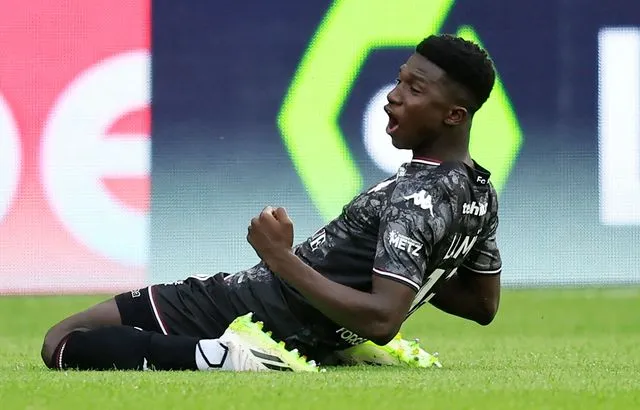 Image de Football. Le dimanche 9 octobre 2023, un jeune joueur sénégalais, Lamine Camara, a inscrit un but mémorable lors du match entre l'AS Monaco et le FC Metz. Camara, âgé de seulement 19 ans, a marqué un but de 58 mètres, devenant ainsi l'auteur du troisième but le plus lointain en Ligue 1 depuis les dix dernières années. Ce moment a attiré l'attention des amateurs de football du monde entier et a révélé un talent prometteur dans le championnat français. La carrière de Lamine Camara a débuté de manière assez atypique. En février 2023, il a été recruté par le FC Metz en provenance de l'AS Génération Foot, un club partenaire basé au Sénégal. Son ascension rapide dans le monde du football l'a conduit à la Ligue 1, où il a fait ses débuts et marqué son premier but impressionnant. Le match contre Monaco a été une opportunité en or pour lui de se faire connaître en France et au-delà. Le but de Camara est survenu dès la 4e minute de la partie, étonnant à la fois ses coéquipiers et ses adversaires. Après qu'Youssouf Fofana, un international français évoluant pour l'AS Monaco, ait perdu le ballon, Camara a saisi l'occasion et a réalisé un lob exceptionnel de 58 mètres. Ce coup de génie a pris de court le gardien monégasque, Philipp Köhn, qui s'était aventuré loin de ses cages. La précision et la vision de jeu de Camara ont été mises en évidence dans cette action spectaculaire. Interrogé sur son but en mi-temps, Lamine Camara a partagé son analyse du moment : « J’avais vu que le gardien était parfois trop loin de ses cages, donc dès que l’occasion s’est présentée, je n’ai pas hésité. » Sa confiance et son sang-froid sur le terrain ont impressionné les fans et les observateurs, confirmant son potentiel en tant que jeune talent à surveiller. Malgré le golazo de Camara, l'AS Monaco a réussi à remporter le match 2-1, grâce à un superbe but d'Alexander Golovine et un coup franc bien exécuté. Cependant, la performance individuelle de Camara a volé la vedette et a suscité des éloges de la part de nombreux experts du football. Monaco est actuellement en tête du classement de la Ligue 1, tandis que Metz se trouve à la 16e place, une position qui souligne la nécessité de résultats positifs pour échapper à la zone de relégation. Le but de Lamine Camara a attiré l'attention de tous les amateurs de football, mais il est également important de le replacer dans le contexte plus large de l'histoire de la Ligue 1. Selon les données fournies par le statisticien OptaJean et citées par L'Équipe, ce but est le troisième but le plus lointain marqué en Ligue 1 depuis que ces statistiques sont enregistrées, à partir de 2013. Seuls deux joueurs ont fait mieux au cours de cette période : Wahbi Khazri a marqué un but de 68 mètres pour Saint-Étienne contre Metz le 30 octobre 2021, et Saber Khalifa a inscrit un but de 64 mètres pour Evian-Thonon-Gaillard contre Nice le 12 mai 2013. Cette réalisation impressionnante de Lamine Camara ouvre la porte à une question fascinante pour les amateurs de football et les observateurs du jeu : quel sera le prochain exploit extraordinaire qui marquera l'histoire de la Ligue 1, et qui sera le joueur ou l'équipe à l'accomplir ? Le football est plein de surprises et de moments magiques, et chaque saison apporte son lot d'exploits inoubliables. Alors, qu'attendons-nous de la prochaine grande surprise sur les terrains de la Ligue 1, et qui laissera une empreinte indélébile dans l'histoire du football français ? Seul l'avenir nous le dira.